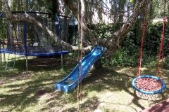 Children's corner with trampoline, slide and swing